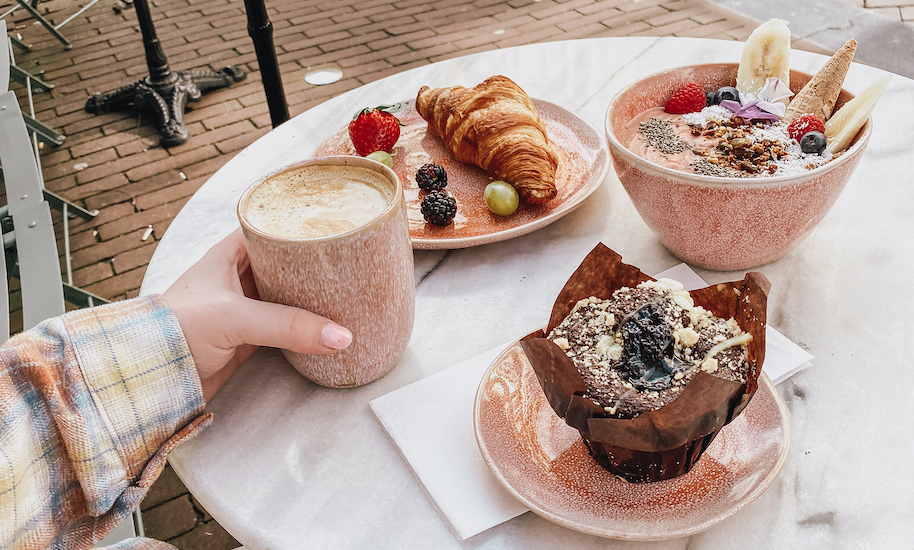 Delicious breakfast with coffee, muffin, croissant and fruit bowl from Pluk